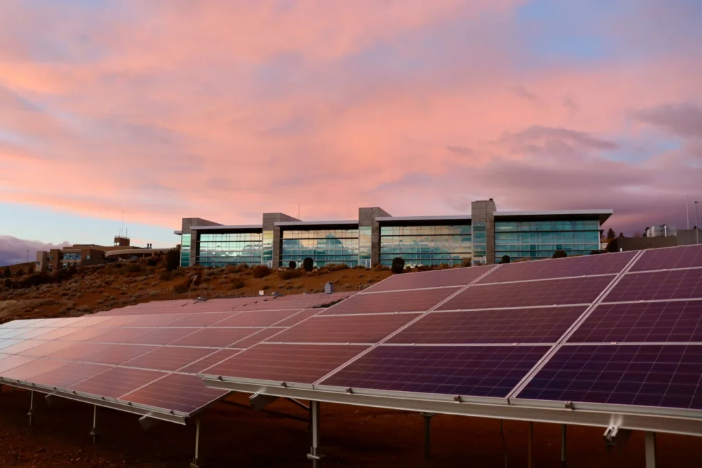 Photovoltaikanlage auf einem Flachdach bei Sonnenuntergang mit farbigem Abendhimmel – Elektrotechnik -Level Up