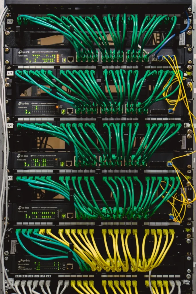 Netzwerkschrank mit Switches und strukturiert verlegten grünen Ethernet-Kabeln – Elektrotechnik -Level Up